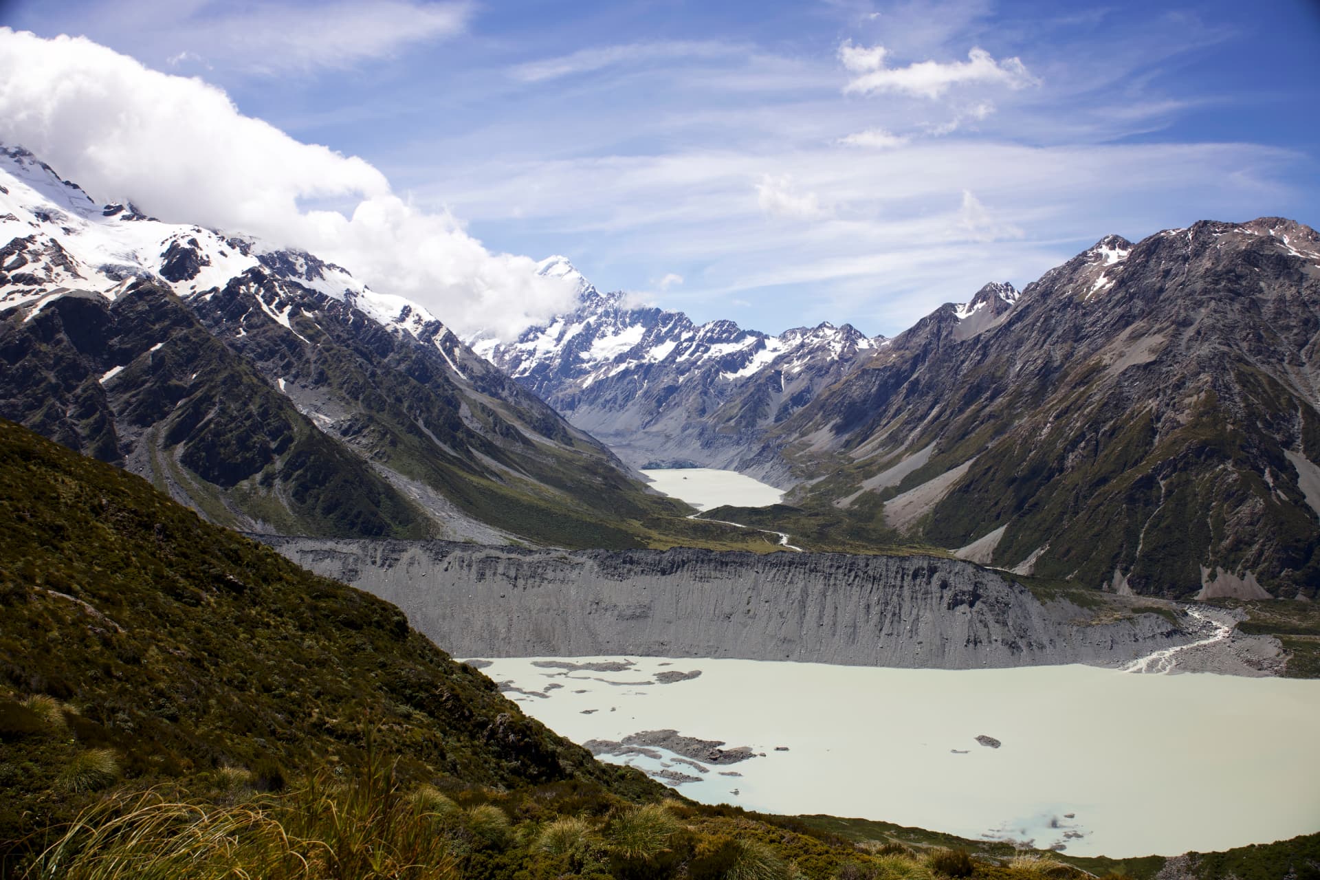 Snow-capped Mount Cook above a turquoise glacier lake and rocky moraine in the Hooker Valley, New Zealand