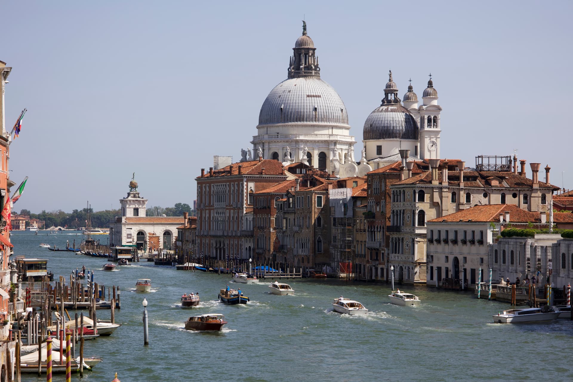 The Grand Canal in Venice with boats passing historic palaces and the domed Santa Maria della Salute basilica, Italy